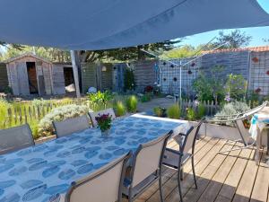 a table and chairs under an umbrella in a garden at Maison 6 personnes in Barbâtre