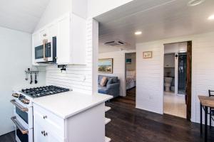 Una cocina y sala de estar con gabinetes blancos y una mesa. en Marysol Cottage, en Edisto Beach