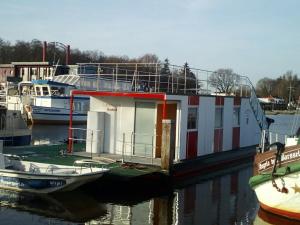 una barca è attraccata a un molo in acqua di Hausboot Levitate im Hafen von Barßel a Barßel Altre 3 foto