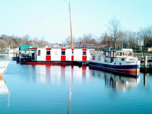 due imbarcazioni ormeggiate in un molo in acqua di Hausboot Levitate im Hafen von Barßel a Barßel