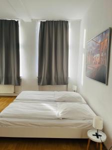 Una cama blanca en una habitación con ventana. en Hotel Westend, en Colonia