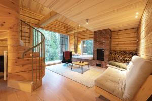 a living room with a couch and a fireplace at Handcrafted Log Chalet Villa Aarreaitta in Syöte