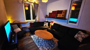 una sala de estar con un sofá y una mesa en Riverfront Aurora Chalet, en Kiruna