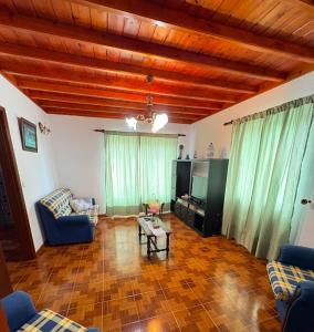 a living room with a couch and a tv at Zizi home in Biscoitos
