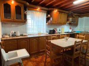a kitchen with wooden cabinets and a table with chairs at Zizi home in Biscoitos