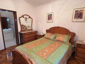 a bedroom with a bed and a mirror at Zizi home in Biscoitos
