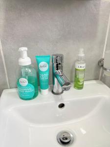 a bathroom sink with two bottles of soap and toothpaste at Hlones place in Rustenburg +25 photos