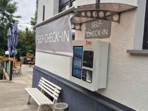 a ticket machine on the side of a building with a bench at Etna Hotel & Ristorante in Veitshöchheim