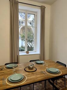 a dining room table with chairs and a window at La vue sacrée in Laon +18 photos