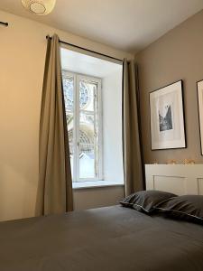 Un dormitorio con una cama y una ventana grande. en La vue sacrée, en Laon