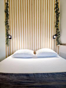 a bed with a headboard and two pillows at SKY - Gîte meublé & confort Drôme - Écolodgîte in Laveyron