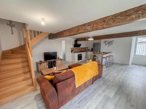 a living room with a brown couch and a table at Entre Bressuire & Thouars- By R&G in Coulonges-Thouarsais