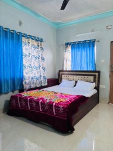 Schlafzimmer mit einem großen Bett und blauen Vorhängen in der Unterkunft Forest villa 2bhk danawali in Panchgani