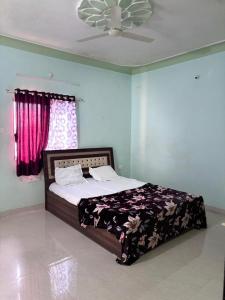 ein Schlafzimmer mit einem Bett und einem Deckenventilator in der Unterkunft Forest villa 2bhk danawali in Panchgani