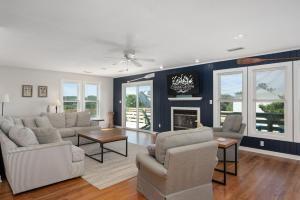 ein Wohnzimmer mit Sofa und Stühlen und einem Kamin in der Unterkunft DK207 The Big Sea in North Point