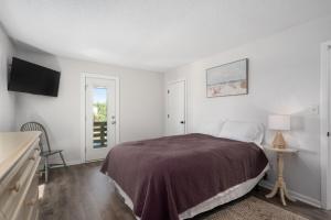 ein weißes Schlafzimmer mit einem Bett und einem Fernseher in der Unterkunft DK207 The Big Sea in North Point + 48 Fotos