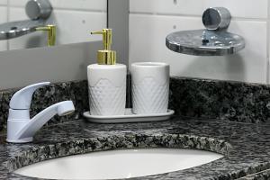 eine Badezimmerablage mit Waschbecken und zwei Toilettenartikeln in der Unterkunft Cobertura duplex de frente pro mar in Natal + 42 Fotos