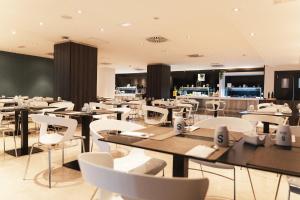 a restaurant with white tables and white chairs at Sercotel Córdoba Medina Azahara in Córdoba