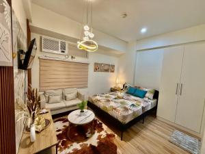 ein Wohnzimmer mit einem Bett und einer Couch in der Unterkunft J&A Cozy Calm Stay in Biñan