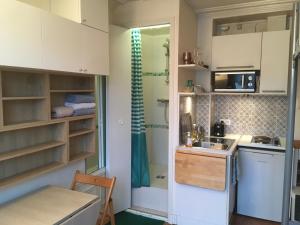 a small kitchen with white cabinets and a sink at STUDIO Doré in Paris