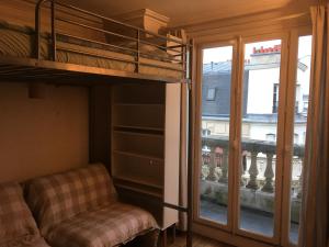 a bedroom with a bunk bed and a chair and a window at STUDIO Doré in Paris