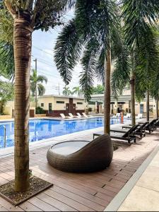 Ein großer Reifen liegt neben einem Pool mit Palmen in der Unterkunft J&A Cozy Calm Stay in Biñan