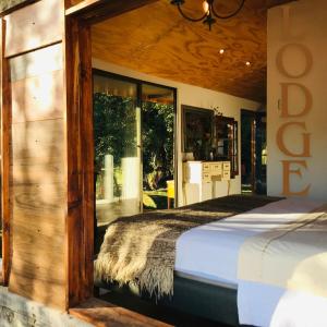 a bedroom with a bed with a large window at Cabina & Tinaja con vista al Rio Maipo in Pirque