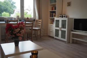 un soggiorno con un vaso di fiori su un tavolo di Appartment Buntspecht - Gemütliche Ferienwohnung, Direkt am Wald, Nähe zur Altstadt a Mölln