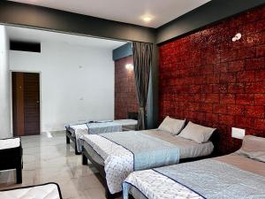 une chambre avec trois lits et un mur de briques dans l'établissement greenSpun nature Stay, à Somvārpet