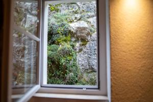 una ventana con vistas a una pared de roca en Lakefront Grand Residence, en Ligerz
