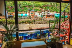 a room with a large window with a view of a mountain at Aguaymanto pisac hostel in Pisac
