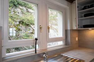 una cocina con 2 ventanas sobre un fregadero en Lakefront Grand Residence, en Ligerz 49 fotos más