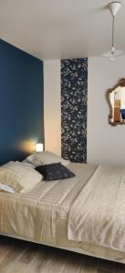 een slaapkamer met een bed en een blauwe muur bij Le Nénuphar in Vernon