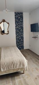 een slaapkamer met een bed en een spiegel aan de muur bij Le Nénuphar in Vernon