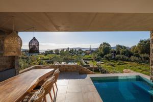 an outdoor patio with a table and a swimming pool at Penthouse Villa with Private Pool, Sauna & Seaview in Gialova