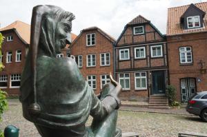 Una statua di una donna davanti a un edificio di Appartment Buntspecht - Gemütliche Ferienwohnung, Direkt am Wald, Nähe zur Altstadt a Mölln