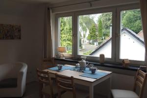 una stanza con un tavolo, delle sedie e una finestra di Appartment Buntspecht - Gemütliche Ferienwohnung, Direkt am Wald, Nähe zur Altstadt a Mölln