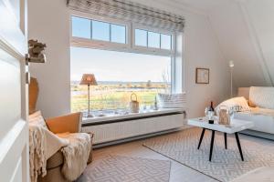 ein Wohnzimmer mit großem Fenster und einer Couch in der Unterkunft KüstenGlück in Langballig