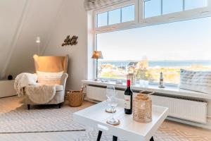 ein Wohnzimmer mit einem weißen Tisch und einem Fenster in der Unterkunft KüstenGlück in Langballig