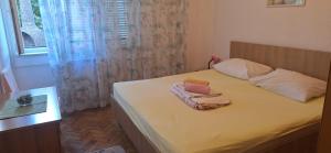 une chambre avec un lit avec deux serviettes dessus dans l'établissement Apartman Villy 2, à Jadranovo