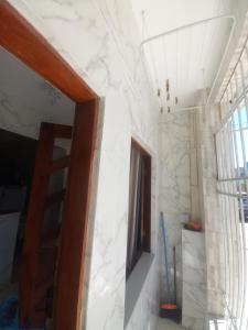 a room with a white marble wall and a ladder at Aracaju Suite - Wi-Fi, Ar e Ótima Localização in Aracaju +13 photos