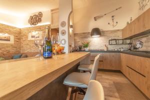 a kitchen with a counter with chairs and wine glasses at Attico Stella Maris in Palau