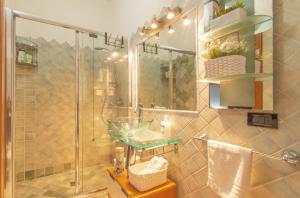 a bathroom with a shower with a sink and a glass shower stall at Attico Stella Maris in Palau +37 photos