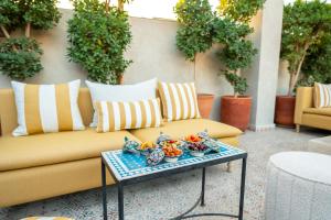 a couch on a patio with a tray of food on a table at Riad Les Yeux Bleus in Marrakesh