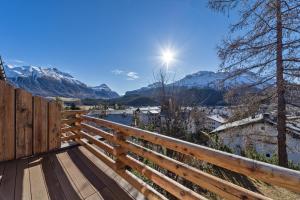 een houten bank met uitzicht op de bergen bij Chesa Prasura - Celerina in Celerina