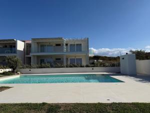 una villa con piscina frente a una casa en Smeraldo Apartment, en Palau