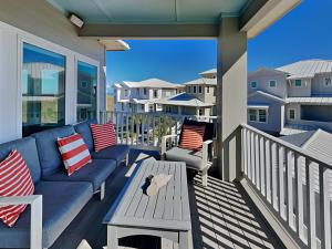 un patio con un divano e un tavolo su un balcone di Salty Kisses a Padre Island Altre 49 foto