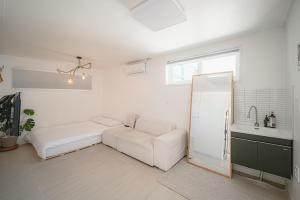 a white living room with a couch and a sink at 신흥부부공간a동 in Hamdŏng-ni