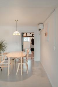 a woman walking into a dining room with a table and chairs at 신흥부부공간a동 in Hamdŏng-ni