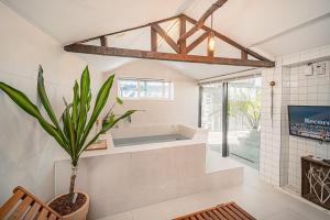 a bathroom with a tub and a potted plant at 신흥부부공간a동 in Hamdŏng-ni